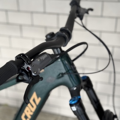 Bicicleta Santa Cruz verde escura com guiador preto e suspensão dianteira