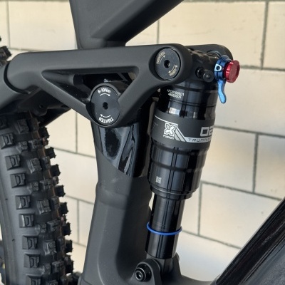 Amortecedor traseiro preto e pivôs numa bicicleta de montanha preta com roda com pneus de cravos