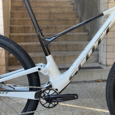 Bicicleta de montanha branca e preta SCOTT junto a escadas em pavimento texturizado