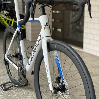 Bicicleta de estrada Colnago branca, preta e azul com travões de disco