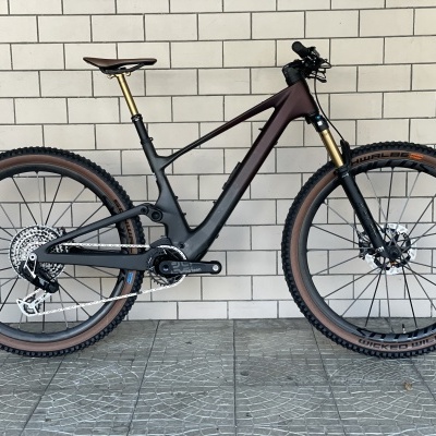 Bicicleta de montanha preta e castanha encostada na parede