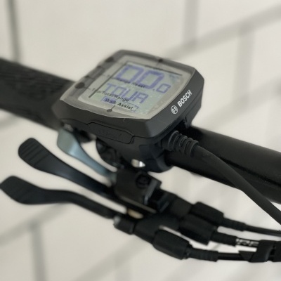 Painel de comando digital Bosch numa bicicleta com mostrador e manetes pretas