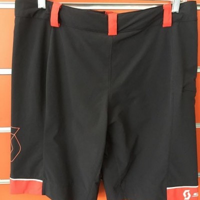 Calções pretos com detalhes vermelhos e logo Scott apresentados em cabide