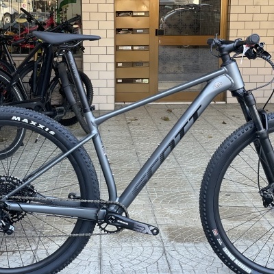 Bicicleta de montanha cinza fosco com pneus Maxxis e suspensão dianteira
