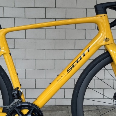 Bicicleta de estrada amarela com quadro em carbono e guiador preto