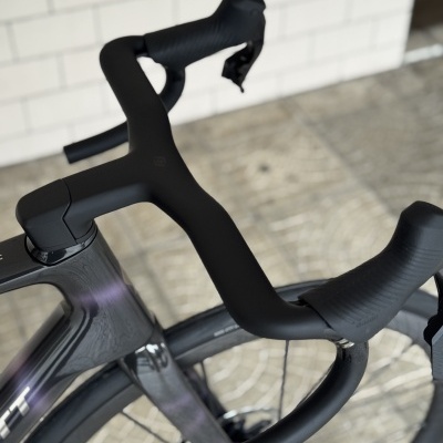 Guiador aero preto e parte do quadro de bicicleta desportiva em carbono