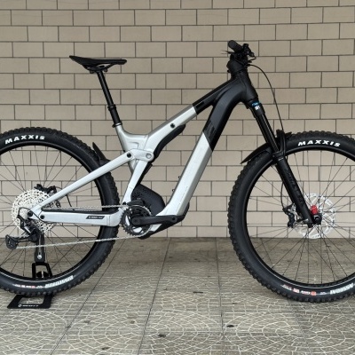 Bicicleta elétrica de montanha preto e cinzento com pneus Maxxis e suspensão dianteira