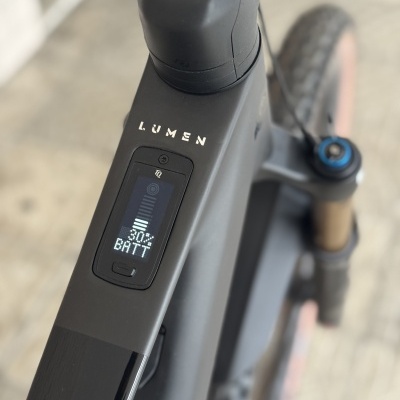 Bicicleta elétrica preta com display de bateria e suspensão dianteira