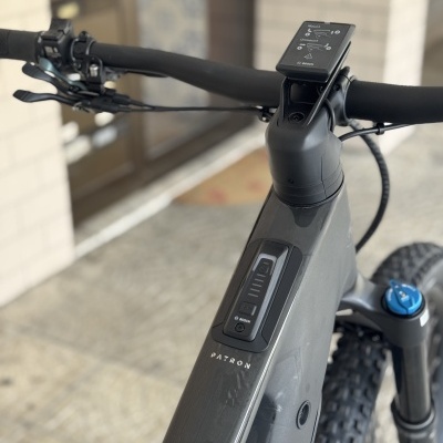 Bicicleta elétrica cinza escuro com ecrã digital e texto PATROL no quadro