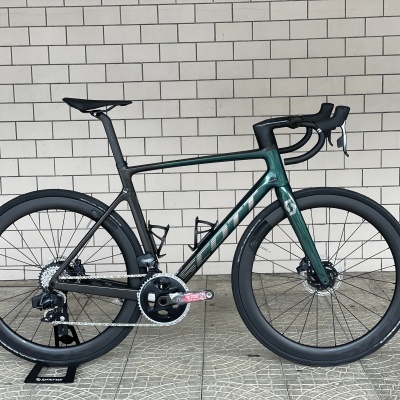 Bicicleta de estrada preta e verde com rodas de perfil alto, guiador curvo e transmissão Shimano