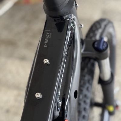 Quadro preto e vermelho de bicicleta elétrica com texto E-REDOX e pneu de terreno acidentado.