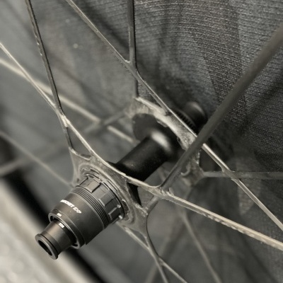 Roda de bicicleta preta com eixo central e peça com texto EDGE DP