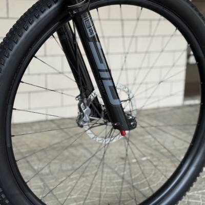 Roda dianteira de bicicleta com pneu preto Maxxis e garfo Rock Shox