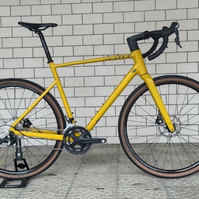 bicicleta de estrada amarela com selim preto e pneus castanhos