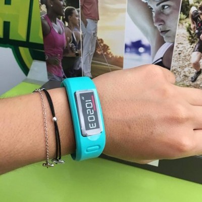 Pulseira digital azul com visor LCD num pulso com duas pulseiras finas