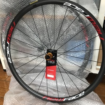 Roda de bicicleta preta com letras NEW RACE em vermelho e branco