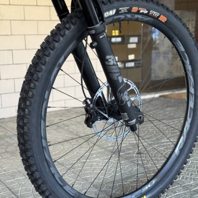 Roda dianteira de bicicleta de montanha com pneu MAXXIS preto e suspensão FOX preta