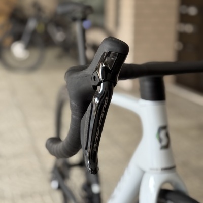 Punho de mudança Shimano preto na bicicleta branca com fundo urbano desfocado