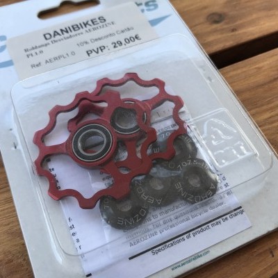 Polias para bicicleta vermelhas e pretas em embalagem plástica sobre cartão branco com texto