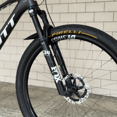 Roda dianteira de bicicleta preta com suspensão FOX e pneu Pirelli