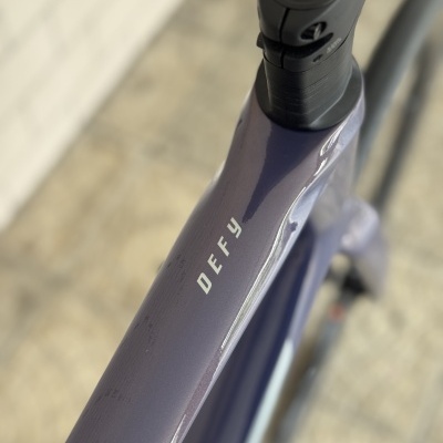 Quadro roxo brilhante de bicicleta com texto branco DEFY
