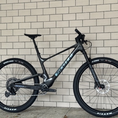 Bicicleta de montanha Scott preta e azul claro junto a parede de azulejos