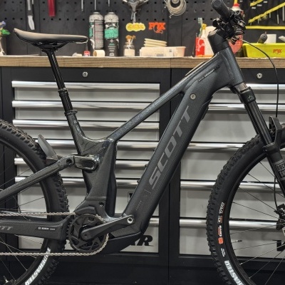 Bicicleta elétrica de montanha SCOTT cinza escuro numa oficina