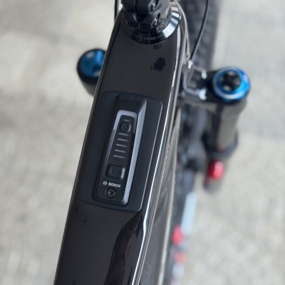 Quadro de bicicleta preta com indicador de bateria BOSCH e suspensão dianteira azul e preta vista de cima