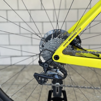 Roda traseira de bicicleta com cassete metálico e desviador Shimano Ultegra num quadro amarelo