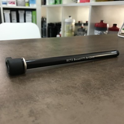 Eixo preto com texto impresso sobre mesa castanha em loja com prateleiras ao fundo