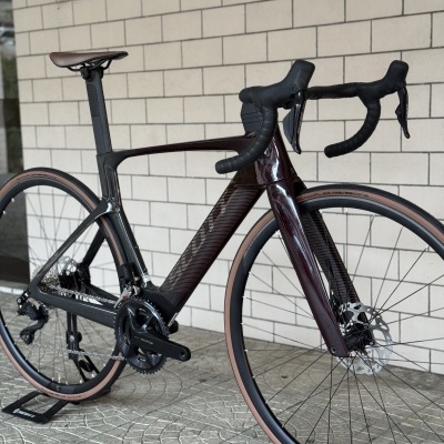 Bicicleta de estrada carbono preto e castanho escuro com pneus castanhos