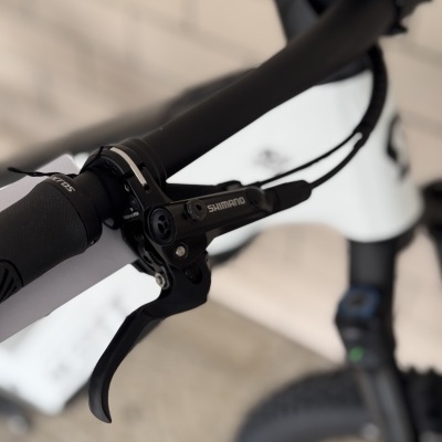 Punho e travão preto e branco de bicicleta com logótipo SHIMANO