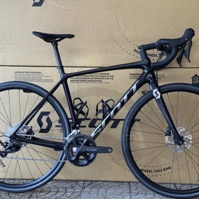 Bicicleta de estrada preta em frente a uma caixa de papelão