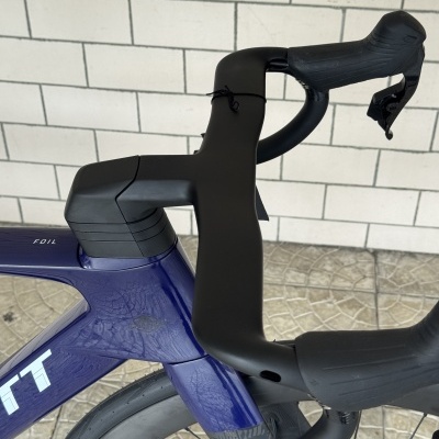 Detalhe do guiador e quadro azul escuro de bicicleta com texto FOIL