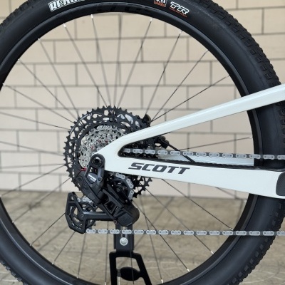 Roda traseira de bicicleta com pneu preto Maxxis Rekon Race e quadro branco SCOTT