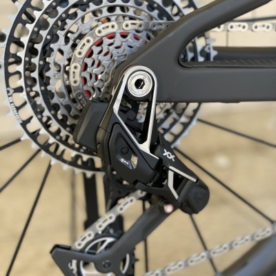 Câmbio traseiro de bicicleta preto e cinzento com corrente prateada e roda dentada metálica