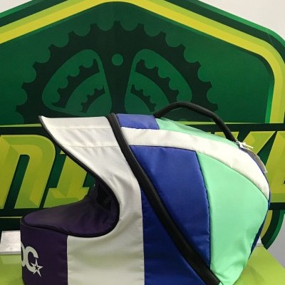 Mochila desportiva colorida com alça preta e logótipo DC em fundo com logótipo verde e amarelo.