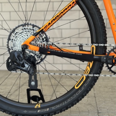 Roda traseira de bicicleta de montanha laranja com corrente e cassete