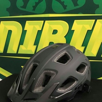 Capacete de bicicleta cinza escuro com várias ventilações em fundo verde e amarelo