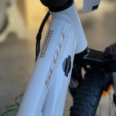 Bicicleta branca SCOTT Contessa com pneus largos e etiqueta 'brother'.