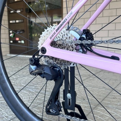 Roda traseira de bicicleta rosa com componentes metálicos e suporte preto