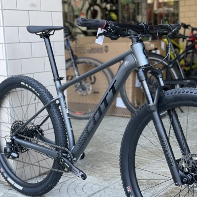 Bicicleta de montanha Scott cinzenta com pneus Maxxis em loja