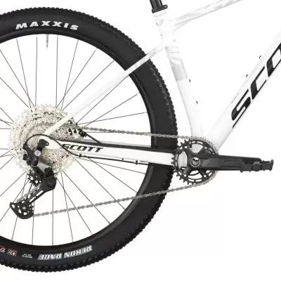 Roda traseira e parte do quadro branco da bicicleta SCOTT com pneu Maxxis preto.