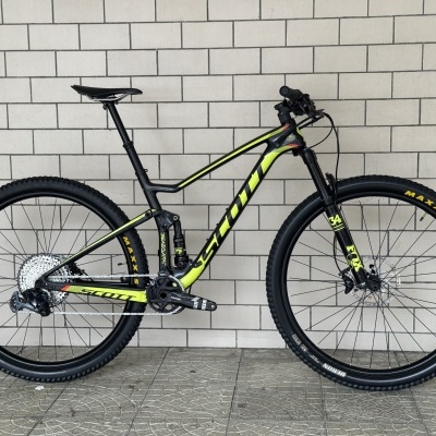 Bicicleta de montanha Scott preto e amarelo junto a parede