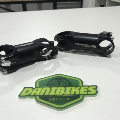 Suportes pretos para guiador de bicicleta com autocolante DANIBIKES BIKE SHOP numa mesa branca
