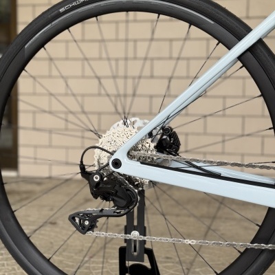 Roda traseira de bicicleta com pneu preto SCHWALBE PRO ONE e quadro azul claro