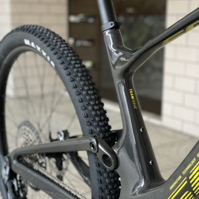 Quadro e roda traseira de bicicleta cinza escuro com detalhes amarelos e pneu MAXXIS