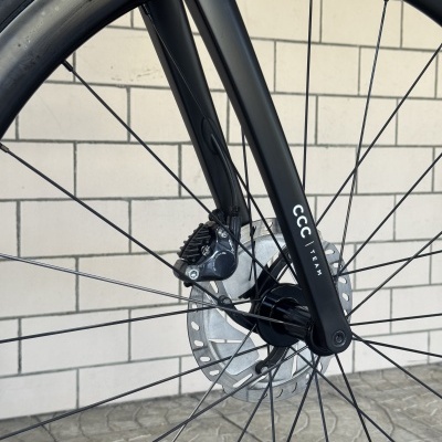 Roda de bicicleta com garfo preto, texto CCC | TEAM e disco de travão