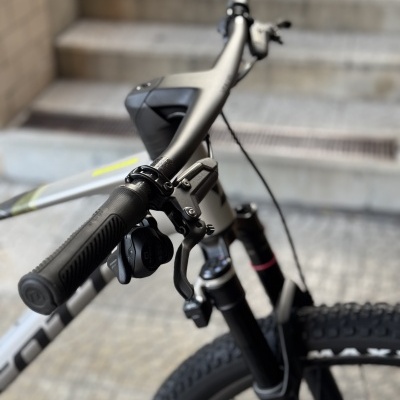 Bicicleta de montanha branca com detalhes pretos e guiador focado junto a escadaria em pedra