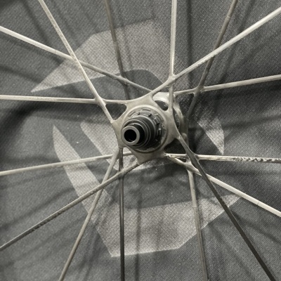 Roda de bicicleta com raios metálicos prateados e eixo central preto